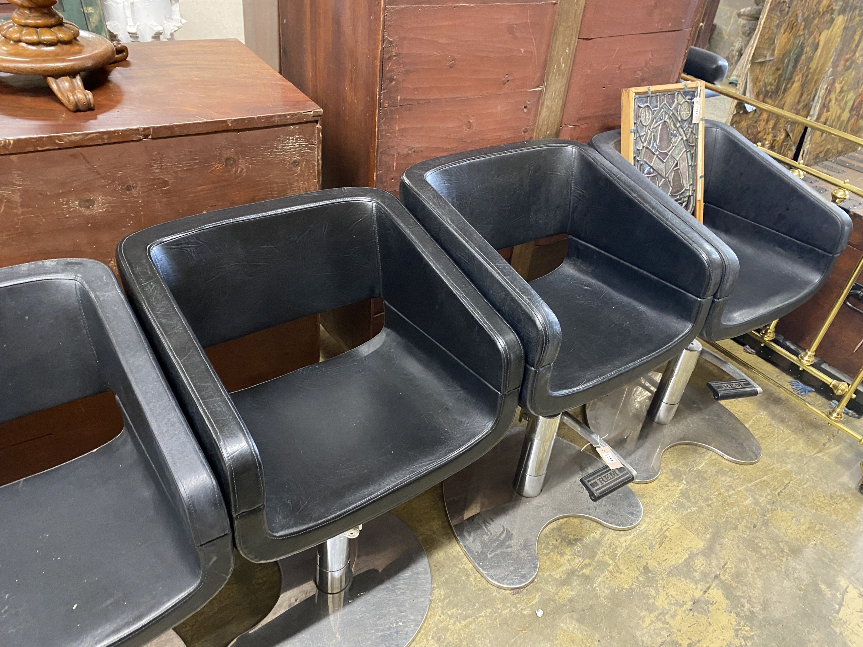 A set of five REM black leatherette and chrome hydraulic salon chairs, width 56cm, depth 42cm